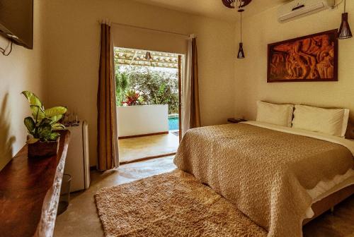 
a bedroom with a large bed and a large window at Pousada Casa de Shiva in Alto Paraíso de Goiás
