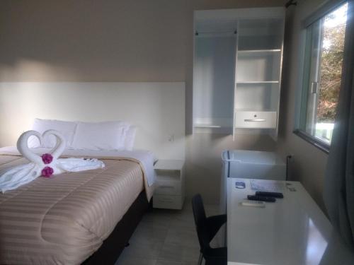 
a white toilet sitting next to a bed in a room at Pousada das Cachoeiras in Alto Paraíso de Goiás
