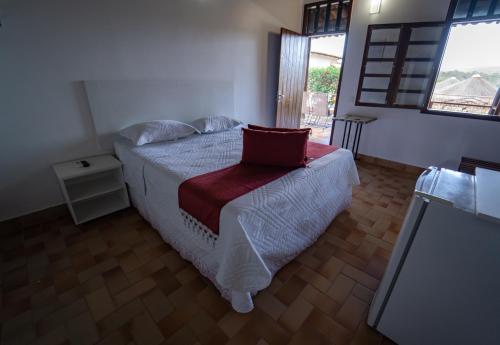 
a bedroom with a bed and a dresser at Pousada Cachoeira Poço Encantado in Alto Paraíso de Goiás
