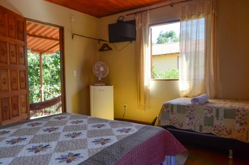 
a bedroom with a bed and a window at Pousada Beija-Flor in Alto Paraíso de Goiás
