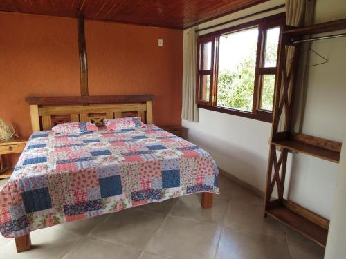 
A bed or beds in a room at Chalés Flor do Sol
